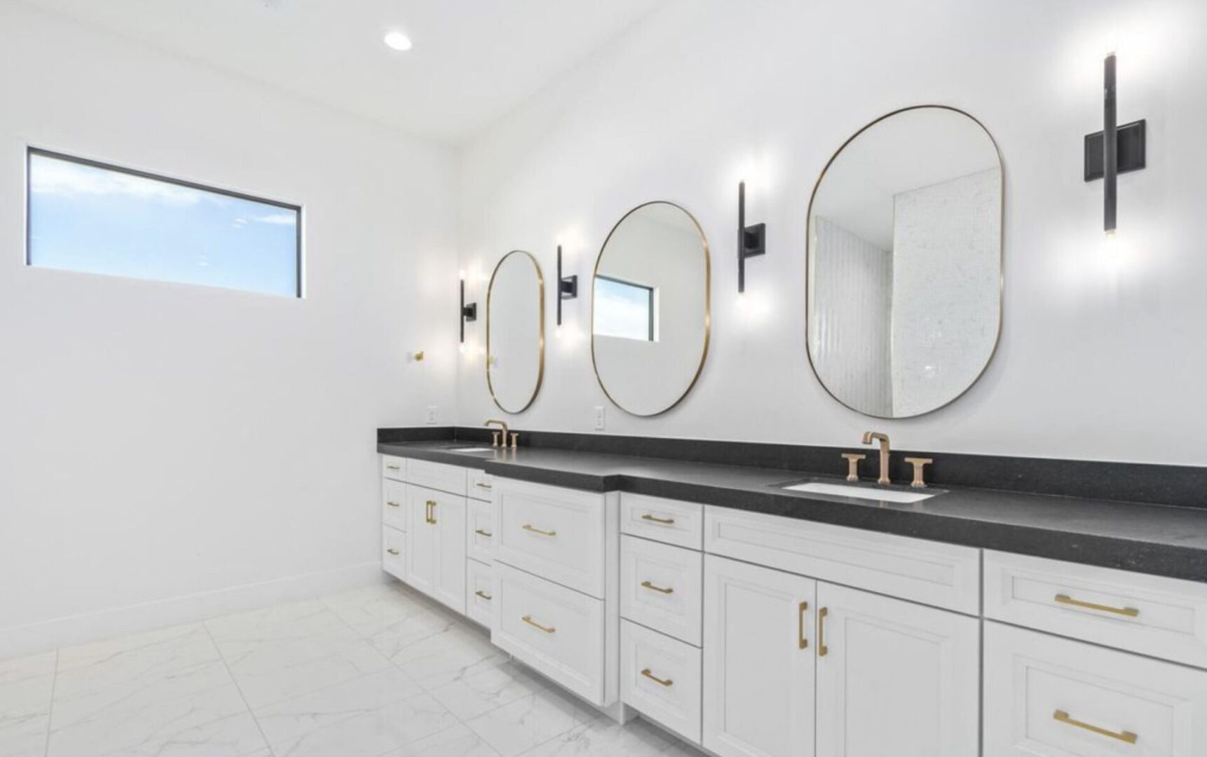 A bathroom with two sinks and three mirrors.