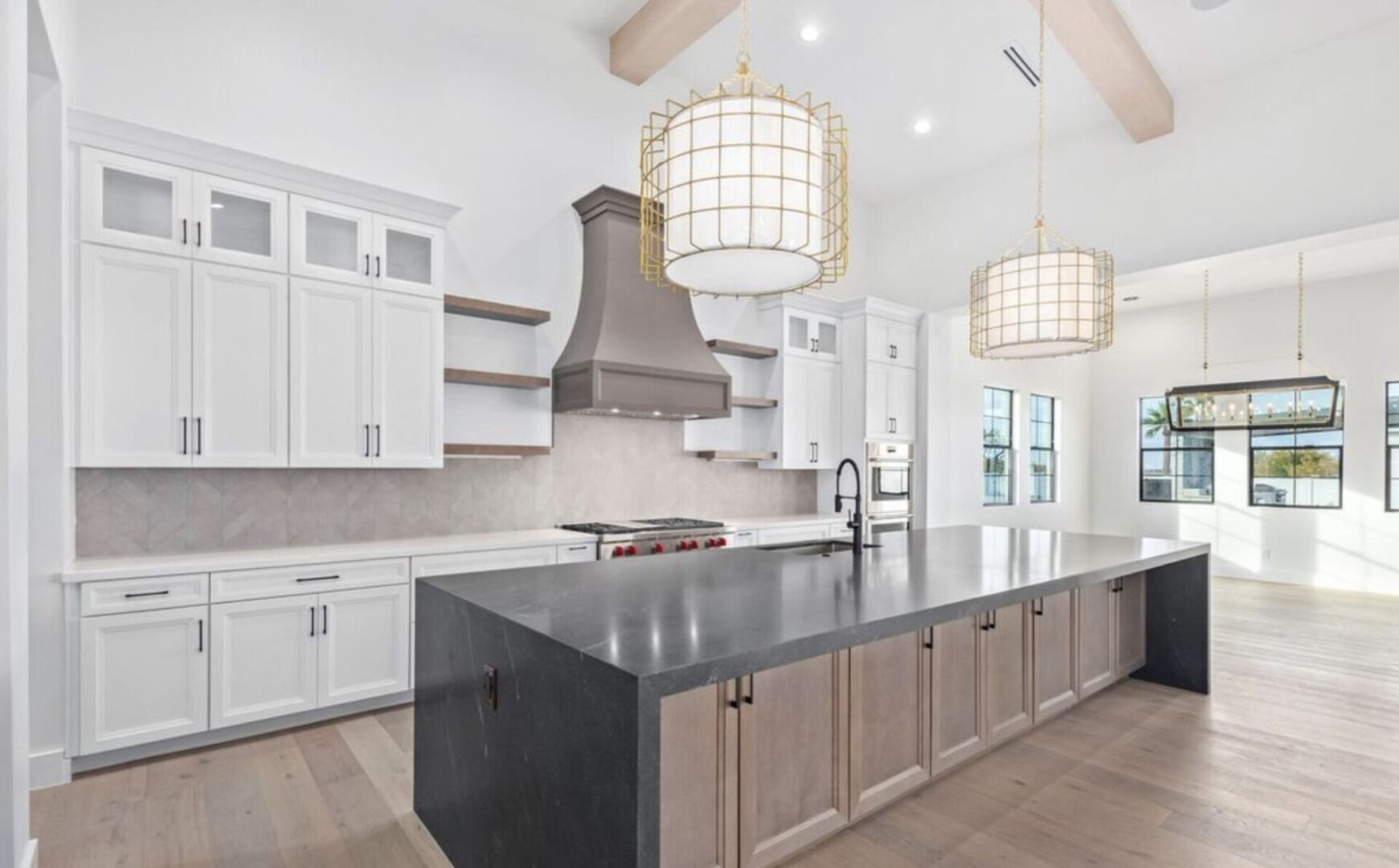 A large kitchen with white cabinets and black island.