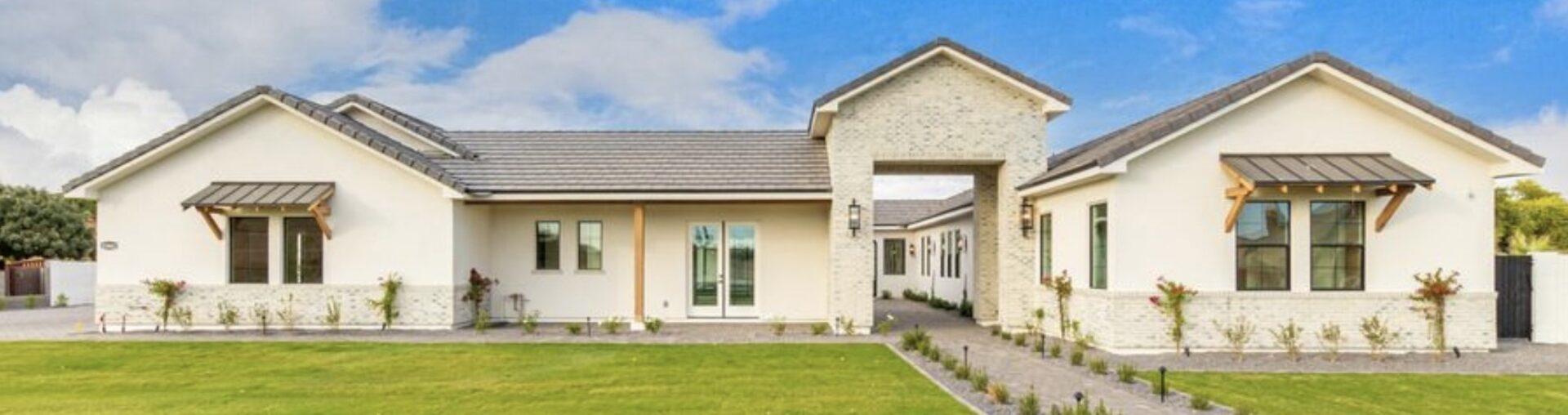 A house with a driveway and lawn in front of it.